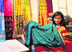 A woman displays a saree at the Silk Mark Expo 2013 in Jammu on Saturday. 
