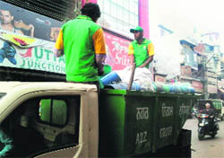 Staff of the A2Z firm lift garbage from the Chaura Bazar in Ludhiana on Saturday. A Tribune photo