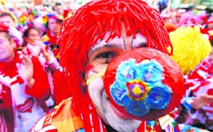 A reveller dressed as a clown poses during the carnival.
