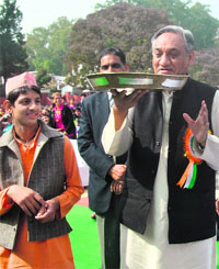 Chief Minister Vijay Bahuguna balances a thali during Jaunsar Bavar Mahotsav in Dehradun on Sunday.