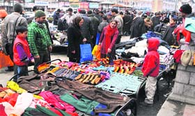 Customers look at clothes at a makeshift market in Srinagar on Sunday
