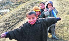 In playful mood: Children pose for a photograph near the Dal Lake in Srinagar on Sunday