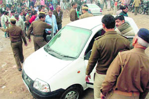 Policemen inspect the car in which a woman was found murdered in Gurgaon on Monday. 