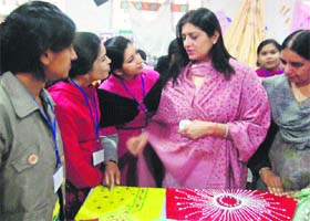 Ramita Batra, wife of MM Education Society president Rajiv Batra, gives tips to students during an exhibition on fashion designing at MM PG College in Fatehabad