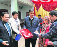 Dhola Sidh project head SK Mahajan gives a cash award to an expectant mother at a camp in Sujanpur on Sunday.