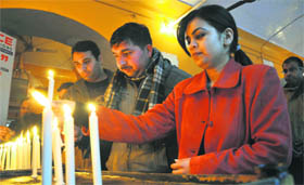 Locals light candles to mark the World Cancer Day in Jammu on Monday.