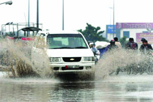 Vehicles wade through a waterlogged road after the morning rain in East Delhi on Tuesday.