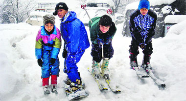 Boys enjoy skiing after a fresh spell of snowfall near Manali on Tuesday. 