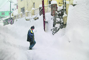A man walks during heavy snowfall in Keylong on Tuesday.