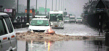 Vehicles crawl on water-logged national highway No 8 near Hero Honda Chowk in Gurgaon after a downpour on Tuesday. 