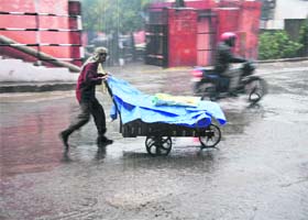 A cart puller caught in the rain in Jammu on Tuesday