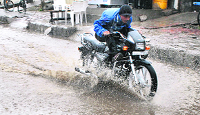 A man wades through the waterlogged road near Samania Gate in Patiala on Tuesday. 