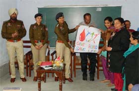 ASP Alka Meena displays one of the many posters made by students during a poster-making competition held at the Government Rajindra College on Wednesday