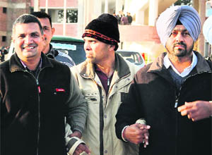 Accused Rakesh Jain (centre) comes out of the new District Courts complex after being produced in a court by the CBI in Sector 43, Chandigarh, on Wednesday. 