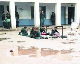 Students sit on a slushy ground at Government High School in Sector 17, Panchkula. 