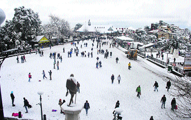 Tourists enjoy heavy snowfall on the Ridge in Shimla on Wednesday.