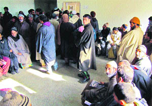 Patients wait outside a ward in a queue to visit doctors at the corridor of SMHS Hospital in Srinagar. 