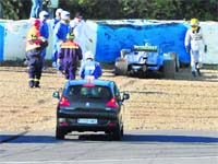 Lewis Hamilton (extreme right) walks away from his car after crashing it into a tyre wall during the second day of testing in Jerez, Spain, on Wednesday