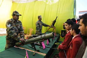 An Army personnel shows the rocket launcher to the students at the fest
