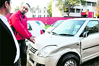 Amit Kumar shows his damaged car at the Sector 39 police station in Chandigarh on Thursday