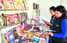 Schoolgirls check books during the ongoing Trade Fair at Ranipur in Haridwar on Thursday. 