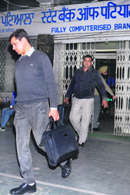 CBI officials come out of a branch of the State Bank of Patiala after checking the bank details of accused income tax officer Rakesh Jain at Sector 22-B, Chandigarh, on Friday. 