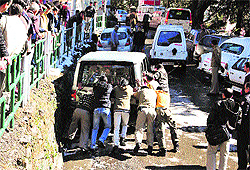 People push a vehicle stuck at Deputy Commissioners office in Shimla on Friday