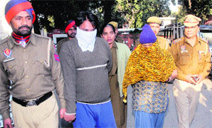 The murder accused (face-covered) in police custody in Jalandhar on Friday. 