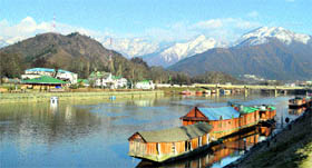 A view of houseboats in the Jhelum river surrounded by snow-bound mountain peaks in Srinagar on Friday.
