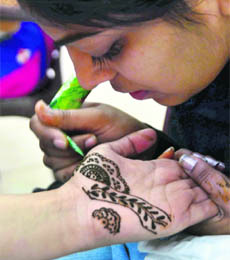 A student takes part in a mehandi competition during Ectopia-2013 at Dayanand Medical College and Hospital in Ludhiana.