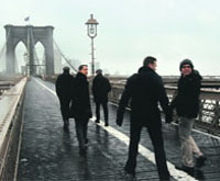 People walk in snow and sleet on the Brooklyn Bridge in New York City on Friday. 