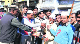 People distribute sweets on the hanging of Afzal Guru in Jwalapur in Haridwar on Saturday.