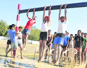 Candidates perform pull-ups during a physical fitness test during an Army recruitment rally at Karan Stadium in Karnal. 