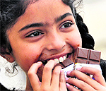 A girl relishes chocolates on Chocolate Day in Ludhiana