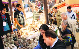 Visitors throng a stall selling articles made of onyx stone at the 27th Surajkund International Crafts Mela
