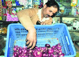 A shopkeeper sells onions at Sakoh village near Dharamsala on Sunday