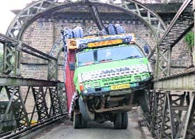 An overloaded truck entangled in the angle iron framework of the Dehar khad bridge at Kotla on the Pathankot-Mandi National Highway on Saturday