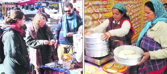 Foreign tourists enjoy Kullu dishes at the Winter Carnival in Manali on Sunday; and (right) local women cook traditional dishes