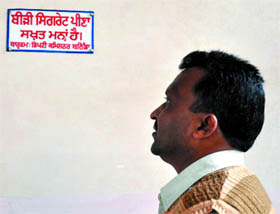 A man looks at a signage on prohibition of smoking in the District Administrative Complex in Bathinda.