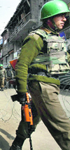 Securitymen patrol a Srinagar street on Monday.