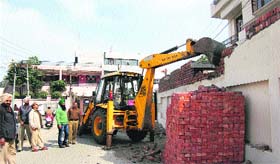 MC staff demolish an illegal construction at Rajinder Nagar in Jalandhar on Monday