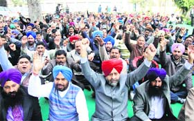 Members of the State Federation of Cooperative Bank Employees Union hold a dharna in Jalandhar Central Cooperative Bank