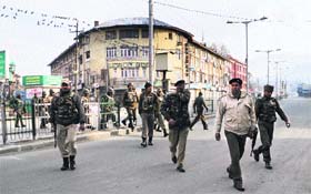 Security personnel patrol a deserted street in Srinagar on Monday
