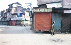 A CRPF jawan stands guard in a deserted area of Lal Chowk on the third day of curfew in the Kashmir valley on Monday