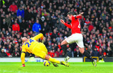 Manchester Uniteds Robin van Persie beats Everton goalkeeper Tim Howard to score during their match in Manchester on Sunday.