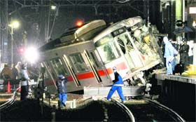 A derailed train on a station platform after it collided with a truck at a level crossing, leaving 10 persons injured, in Takasago, Japan, on Tuesday