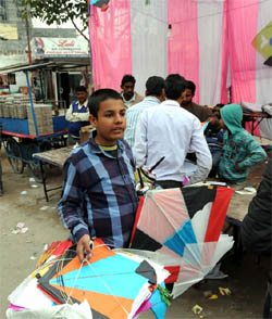 A young boy has both his hands full after buying kites and spools of kiteline from a shop on Amrik Singh Road in Bathinda on Wednesday.