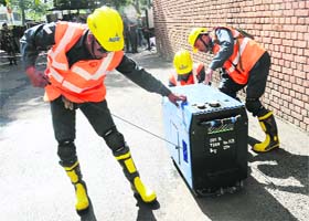 Personnel try hard to start a faulty power generator at the UT Secretariat