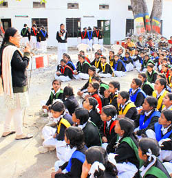 A woman police official of the womens help desk addresses girl students at a Lakhi Bagh school in Dehradun on Wednesday.