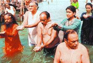 Chief Minister Vijay Bahuguna, along with his family members, takes a holy dip in Prayag on Wednesday.